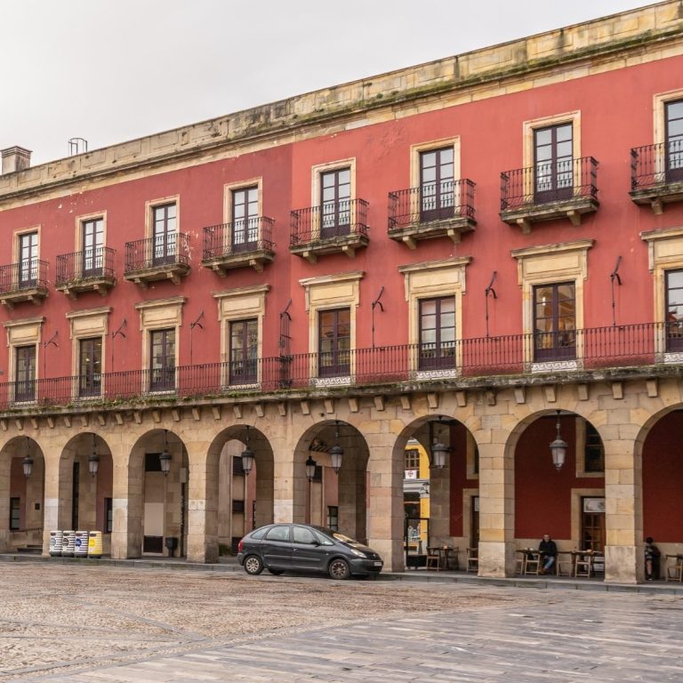 Photo of London gherkin building on the right and two construction cranes on the left. 